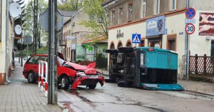 Kolizja drogowa. Na zdjęciu czerwony Volkswagen Passat z wgnieconym dachem po zderzeniu z dostawczym busem.