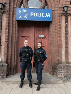 policjanci stojący przed wejściem do KMP Olsztyn